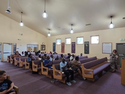 Congregation seated in pews with teacher at front — VBS Day 1