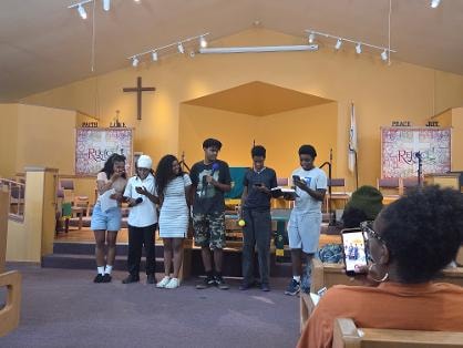 Youth group gathered at the front of the sanctuary — VBS Day 3 Assembly