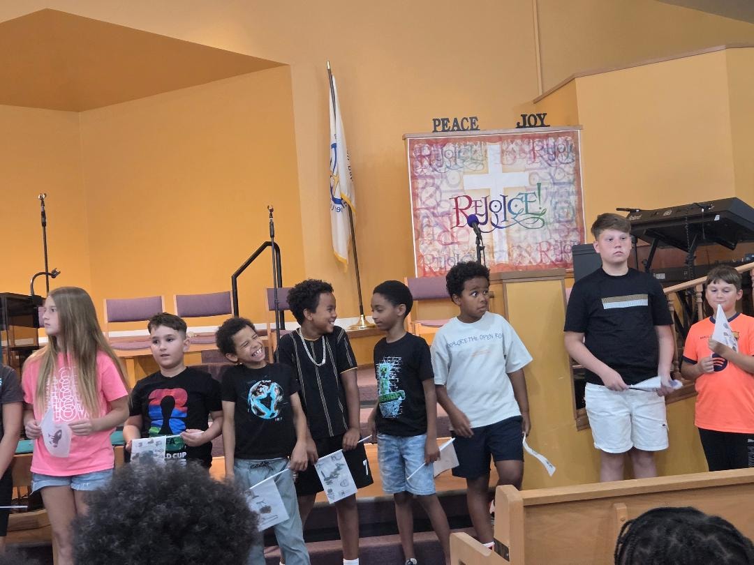 Children gathered on stage at the sanctuary — VBS Day 3 Assembly